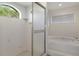 Clean bathroom with a shower, tub, and large window at 9410 Fox Hollow Ln, Weeki Wachee, FL 34613