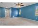 Spacious bedroom with light blue walls and carpeted floors at 9410 Fox Hollow Ln, Weeki Wachee, FL 34613