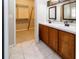 Bathroom featuring dual sinks, framed mirrors, vanity cabinet, and an adjacent walk-in closet at 2529 Sandy Hill Ct, Holiday, FL 34691