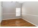 Light-filled bedroom with modern wood-look floors and large window with blinds at 2529 Sandy Hill Ct, Holiday, FL 34691