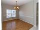 Dining room featuring hardwood floors, a chandelier, and natural light from a large window at 2529 Sandy Hill Ct, Holiday, FL 34691