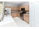 Well-lit kitchen featuring stainless steel appliances, light wood cabinets, tile floors and white double basin sink at 2529 Sandy Hill Ct, Holiday, FL 34691
