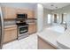 Well-equipped kitchen with stainless steel appliances, light wood cabinetry, and tile flooring at 2529 Sandy Hill Ct, Holiday, FL 34691