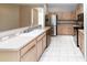 Modern kitchen with stainless steel appliances, light wood cabinets, and a large breakfast bar at 2529 Sandy Hill Ct, Holiday, FL 34691