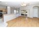 Open living space with wood-look floors adjacent to kitchen, dining nook, and access to enclosed lanai at 2529 Sandy Hill Ct, Holiday, FL 34691