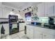 Kitchen features white cabinets, granite countertops, and modern lighting fixtures with views into the dining area at 3178 Sea Grape Dr, Hernando Beach, FL 34607