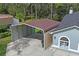 Tan and brown metal carport next to house at 27949 Ravens Brook Rd, Wesley Chapel, FL 33544