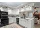 Modern kitchen with white cabinets and black appliances at 27949 Ravens Brook Rd, Wesley Chapel, FL 33544