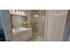 Bright bathroom featuring a glass enclosed shower, white vanity with double sinks, and tile floors at 3605 Kings Rd # 102, Palm Harbor, FL 34685
