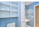 Bathroom featuring blue walls, a pedestal sink, and plenty of open shelving for storage at 3605 Kings Rd # 102, Palm Harbor, FL 34685