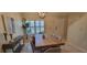 Bright dining room featuring a wooden table, seating for six, and natural light streaming through shuttered windows at 3605 Kings Rd # 102, Palm Harbor, FL 34685