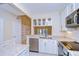 Updated kitchen featuring granite counters, stainless appliances, white cabinets, and tile floors at 3605 Kings Rd # 102, Palm Harbor, FL 34685