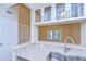 Updated kitchen with stainless steel sink, granite counters, and glass front upper cabinets at 3605 Kings Rd # 102, Palm Harbor, FL 34685