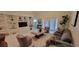 Bright living room features built-in shelving, tile floors, comfortable seating, and sliding glass doors at 3605 Kings Rd # 102, Palm Harbor, FL 34685