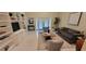 Bright living room features built-in shelving, tile floors, comfortable seating, and sliding glass doors at 3605 Kings Rd # 102, Palm Harbor, FL 34685
