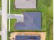 Birds-eye view of new construction home with paved driveway, dark roof, and lush green landscaping at 19395 Sheltered Hill Dr, Brooksville, FL 34601