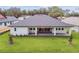 Aerial view of the backyard featuring a covered patio and lush lawn at 19395 Sheltered Hill Dr, Brooksville, FL 34601
