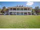 Inviting two-story house featuring a spacious, column-lined veranda and a lush green lawn at 19395 Sheltered Hill Dr, Brooksville, FL 34601