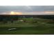 Scenic golf course view at sunset, featuring rolling greens, sand traps, and distant trees at 19395 Sheltered Hill Dr, Brooksville, FL 34601