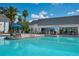 Inviting swimming pool area featuring a bar, seating, sun umbrellas and people enjoying the space at 19395 Sheltered Hill Dr, Brooksville, FL 34601