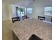 Bright dining area with a large island, granite countertop, and sliding door access to the outdoor space at 8535 Bella Via, Hudson, FL 34667