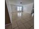 Bright, empty living room with neutral tile, blank canvas ready for your personal touch at 8535 Bella Via, Hudson, FL 34667