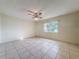 Minimalist bedroom with neutral walls, tiled flooring, and a ceiling fan at 10824 Peppertree Ln, Port Richey, FL 34668