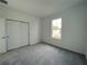 Bright bedroom with grey carpet, neutral walls, and a window at 13447 Newport Shores Dr, Hudson, FL 34669