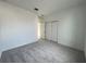 Well-lit bedroom with grey carpet and double door closet at 13447 Newport Shores Dr, Hudson, FL 34669