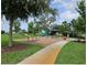 Community playground with swings, slides, and shaded seating at 13447 Newport Shores Dr, Hudson, FL 34669