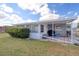 House exterior features a covered patio and landscaped yard at 1542 Derrick St, Holiday, FL 34690