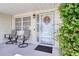 Inviting front porch with rocking chairs, entry door, and seasonal wreath at 1542 Derrick St, Holiday, FL 34690