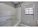 Clean bathroom with a bathtub and shower, grey walls, and a window at 3912 W San Pedro St, Tampa, FL 33629