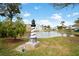 Landscaped pond with lighthouse statue and fountain at 6704 Hickorywood Ln # 2B, New Port Richey, FL 34653