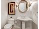 Elegant powder room with pedestal sink and oval mirror at 804 S Fremont Ave, Tampa, FL 33606