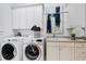 Bright laundry room, featuring a built-in sink, white cabinets, and modern washer and dryer at 804 S Fremont Ave, Tampa, FL 33606