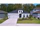 Craftsman style home with gray exterior, two-car garage, and landscaped lawn at 11389 Weaver Hollow Rd, New Port Richey, FL 34654