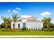White one-story house with a two-car garage and palm trees at 10005 Zennia Ln, Parrish, FL 34219