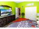 Bedroom with lime green walls, wood-look floors, and a large dresser at 12528 Roseland Dr, New Port Richey, FL 34654