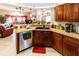 Open kitchen with island, wood cabinets, and stainless steel dishwasher at 12528 Roseland Dr, New Port Richey, FL 34654