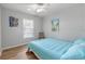 Bedroom with light blue bedding and wood floors at 10516 Moshie Ln, San Antonio, FL 33576