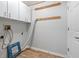 Laundry room with white cabinets, wood flooring, and mirror at 10516 Moshie Ln, San Antonio, FL 33576