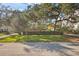 Landscaped front yard, featuring mature trees and lush grass at 2303 S Hesperides St, Tampa, FL 33629