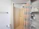 Bathroom with shower, striped curtain, and storage shelves at 12637 2Nd Isle, Hudson, FL 34667