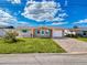 Cute bungalow with teal door, brick paver driveway, and landscaped lawn at 12637 2Nd Isle, Hudson, FL 34667