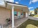 Brick front porch with teal door, white columns, and landscaping at 12637 2Nd Isle, Hudson, FL 34667