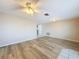 Open living room with wood-look floors, leading to the kitchen and dining area at 12637 2Nd Isle, Hudson, FL 34667