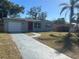 Cute newly renovated home with a gray exterior, red door, and a long driveway at 7142 Carlow St, New Port Richey, FL 34653