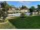 Waterfront backyard with lush lawn and white picket fence at 1354 Linstock Dr, Holiday, FL 34690