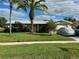 Tan, single-story home with a spacious front yard at 1354 Linstock Dr, Holiday, FL 34690